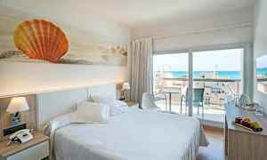 Ett hotellrum med en dubbelsäng, dekorativ konst av en orange snäcka på väggen och en altan med havsutsikt. (AI-genererad text)