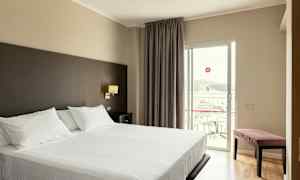 Hotellrum med en dubbelsäng och balkong. (AI-genererad text)