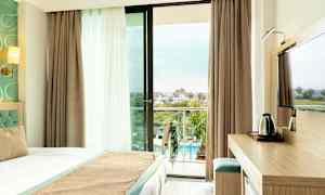 Hotellrum med balkong som har utsikt över poolområdet. (AI-genererad text)