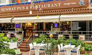 En utomhusterass av en restaurang med bord och stolar. (AI-genererad text)