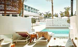 Solstolar vid en pool med modern arkitektur i bakgrunden. (AI-genererad text)