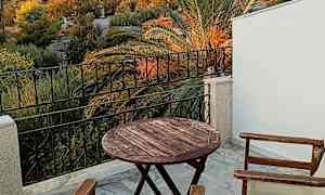 Utsikt från en terrass med bord och stolar samt en slott på en kulle i bakgrunden. (AI-genererad text)