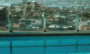 Frukost serverad vid kanten av en pool med utsikt över stadens hustak och Galatatornet. (AI-genererad text)