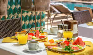 En uppdukad hotellfrukost vid poolområdet. (AI-genererad text)