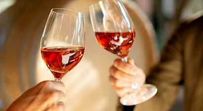 Två glas med rosévin hålls upp. (AI-genererad text)