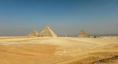 Bilden visar de stora pyramiderna i Giza omgivet av ökenlandskap. (AI-genererad text)