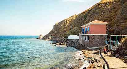 Hus vid havet bredvid en klippa. (AI-genererad text)