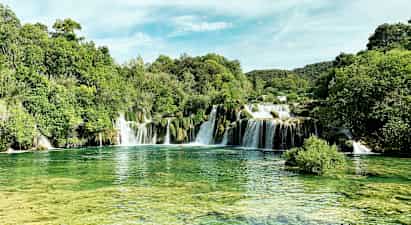 Ett naturskönt vattenfall omringat av frodig grönska. (AI-genererad text)