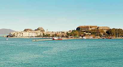 En stad vid havet med historiska byggnader och en fästning på en höjd. (AI-genererad text)