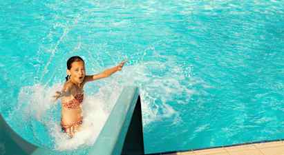 Person som åker nerför en vattenrutschkana in i en pool. (AI-genererad text)