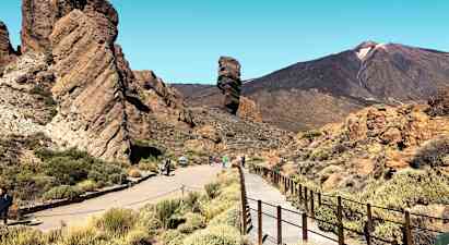 En stenformation med gångväg och berg i bakgrunden. (AI-genererad text)