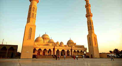 En stor moské med två höga minareter och kupoler. (AI-genererad text)