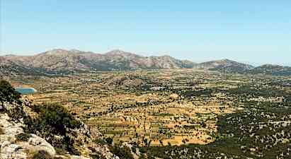 En vidsträckt dal omgiven av berg med betesmarker och odlingsfält. (AI-genererad text)