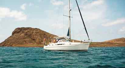 Segelbåt på vatten med berg i bakgrunden. (AI-genererad text)