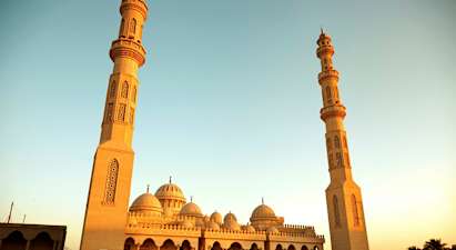 En stor moské med två höga minareter och kupoler. (AI-genererad text)