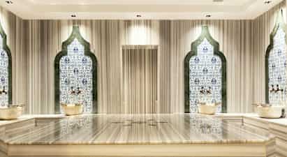 Hamam-rum med mosaikväggar och marmorbänk. (AI-genererad text)