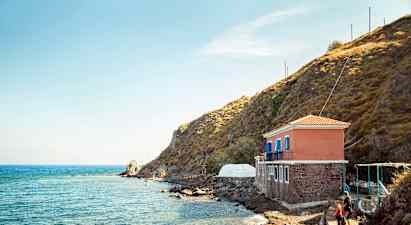 Hus vid havet bredvid en klippa. (AI-genererad text)