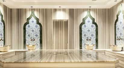 Hamam-rum med mosaikväggar och marmorbänk. (AI-genererad text)