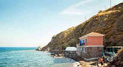 Hus vid havet bredvid en klippa. (AI-genererad text)