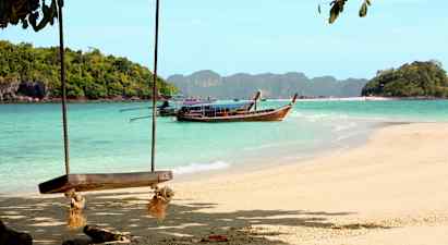 Strand med gunga och en träbåt på vattnet framför skogsklädda öar. (AI-genererad text)