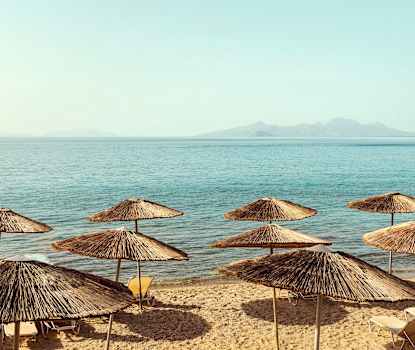 Stranden nedanför hotellet. Solstolarna byttes ut sommaren 2025 och ser därför annorlunda ut än på bilden