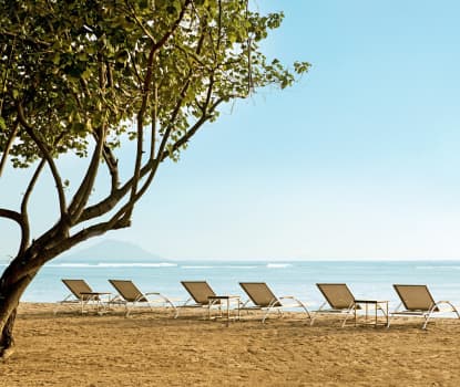 På stranden utanför hotellet erbjuds gratis solstolar för hotellets gäster