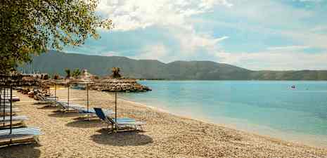 Strand med solstolar och parasoll vid havet. (AI-genererad text)