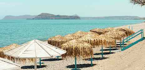 Strand med parasoller och hav i bakgrunden. (AI-genererad text)