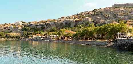 Bild av en kustby med hus belägna på en klippa. (AI-genererad text)