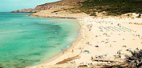 En strand med klart havsvatten, sand och människor som solar och badar. (AI-genererad text)