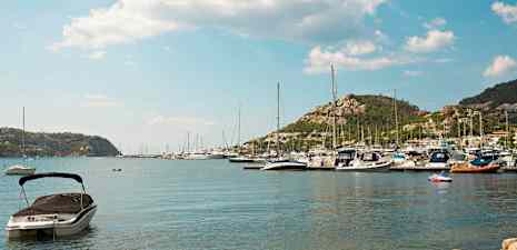 Bild av en hamn med båtar och berg i bakgrunden. (AI-genererad text)