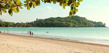 En sandstrand med människor, havet och en skogig ö i bakgrunden. (AI-genererad text)