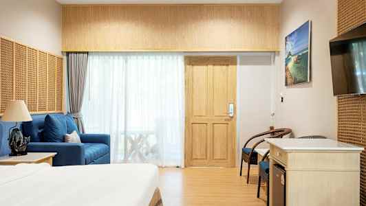 Hotellrum inrett med säng, sittmöbler och TV. (AI-genererad text)