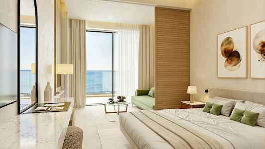 Ett modernt hotellrum med havsutsikt, möblerat med en stor säng, en grön soffa och en balkong. (AI-genererad text)