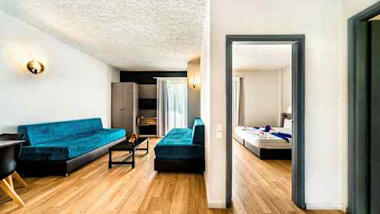 Ett hotellrum med ett vardagsrum och ett sovrum. (AI-genererad text)