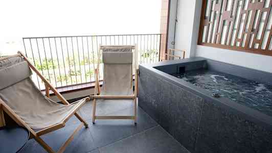 Uteplats med två solstolar och en jacuzzi. (AI-genererad text)