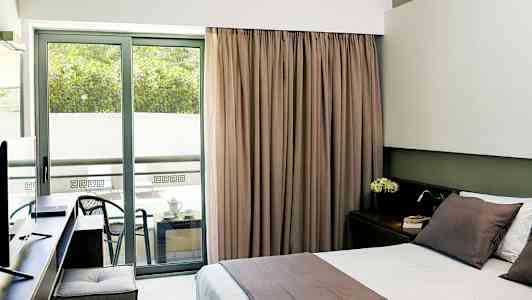 Hotellrum med dubbelbädd och balkong med sittmöbler. (AI-genererad text)