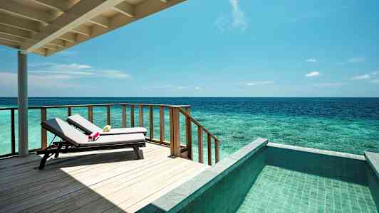 En terrass med solstolar, havsutsikt och en pool. (AI-genererad text)