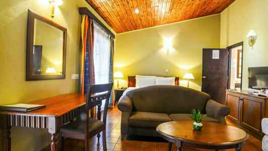 Ett rum med säng, soffa, bord, skrivbord och dekorationer. (AI-genererad text)