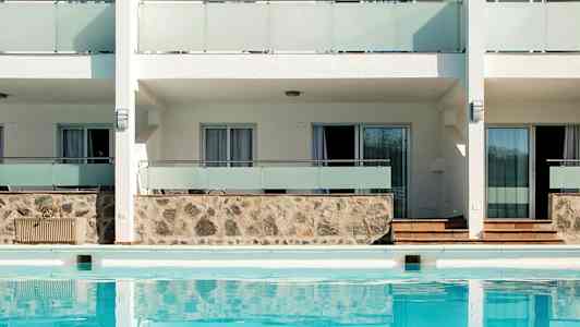 Exteriör av byggnad med pool framför. (AI-genererad text)