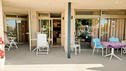 Bild av två terrasser med sittmöbler framför glasdörrar som leder in i lägenheter. (AI-genererad text)