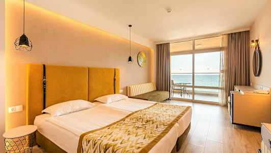 Bild av ett hotellrum med en dubbelsäng och en utsikt mot havet från ett fönster. (AI-genererad text)