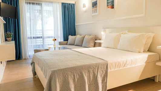 Ett hotellrum med en stor säng, soffa och bord. (AI-genererad text)