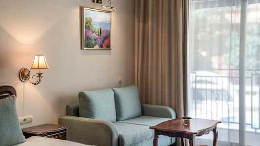 Interiör av ett hotellrum med soffa, bord och säng. (AI-genererad text)