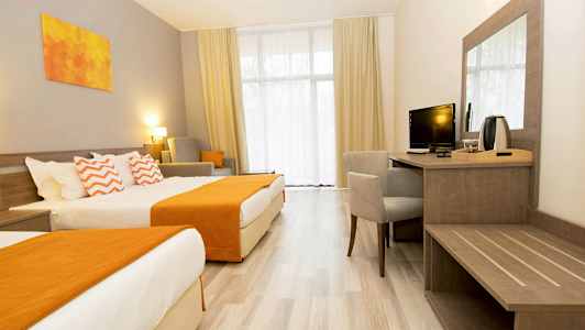 Ett hotellrum med två sängar, en skrivbordshörna och sittmöbler. (AI-genererad text)