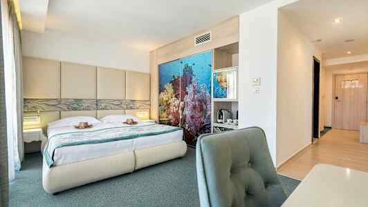 Bild av ett hotellrum med en dubbelsäng, havsinspirerat dekor bakom sängen och skrivbord med stol. (AI-genererad text)