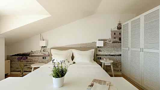 Sovrum med en dekorativ vägg med motiv av hav och byggnader. (AI-genererad text)