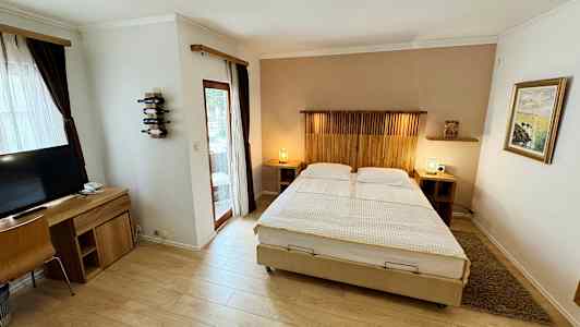 Bild av ett hotellrum med dubbelsäng, skrivbord och TV. (AI-genererad text)