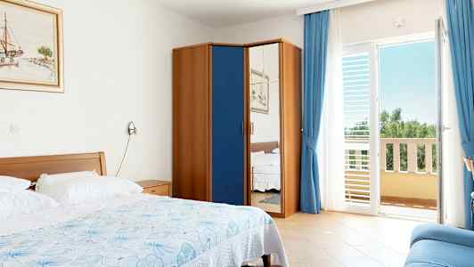 Ett hotellrum med en säng, en garderob med spegeldörr och en balkong. (AI-genererad text)