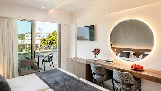 Modernt hotellrum med säng, spegel, skrivbord, stolar och balkong. (AI-genererad text)